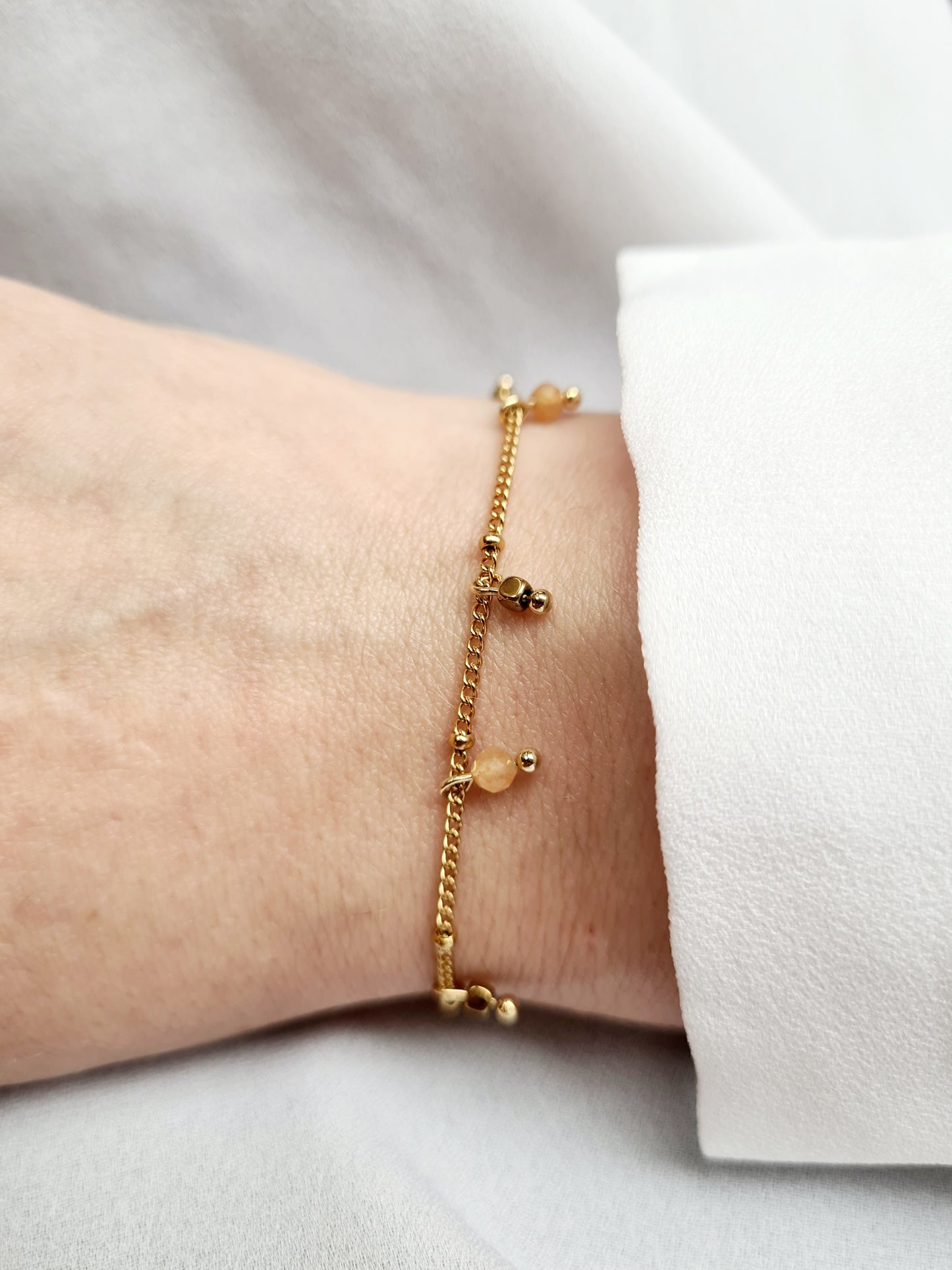 Mirage est un bracelet en acier inoxydable doré composé de véritables pierres naturelles