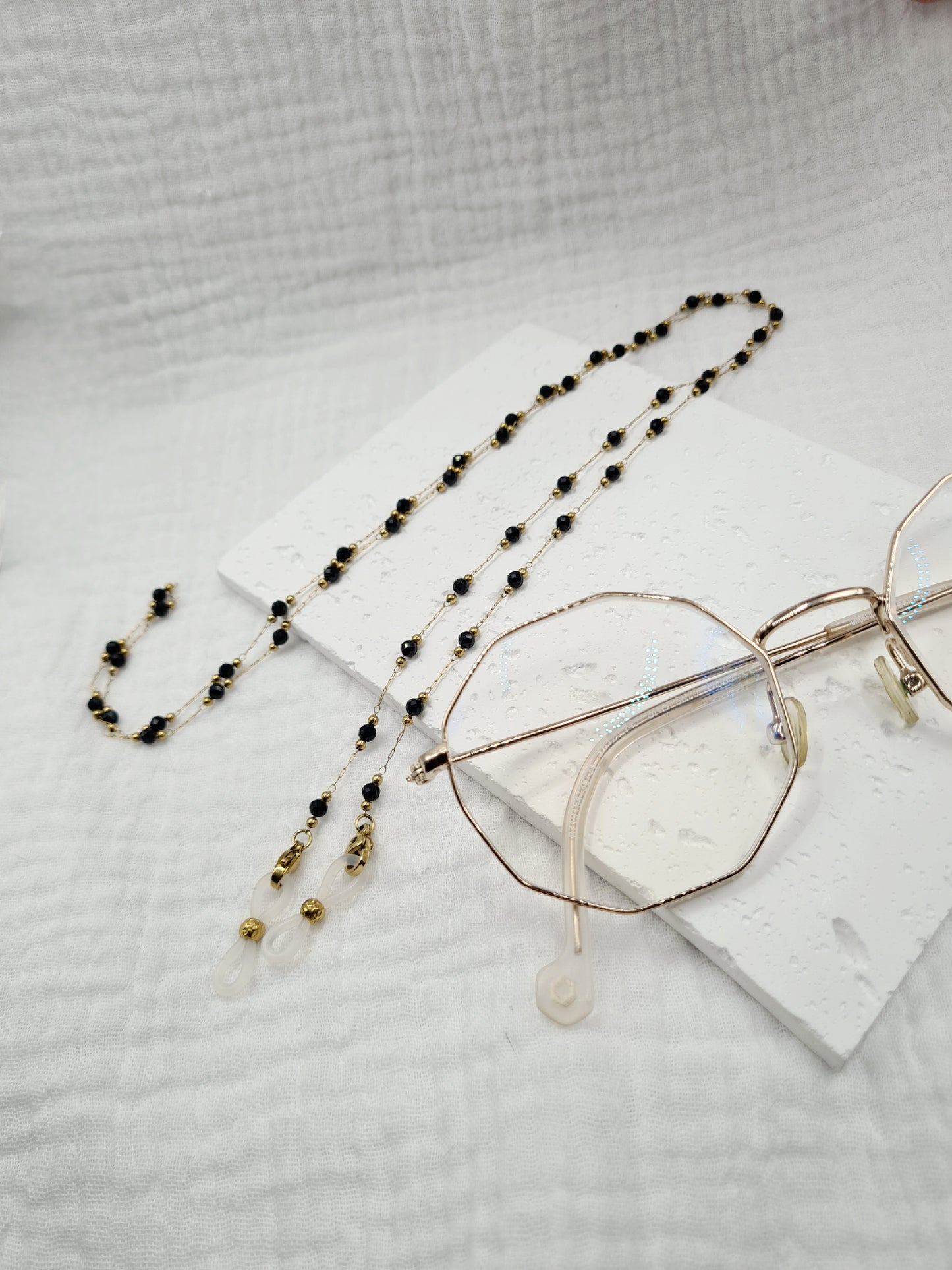 Sigrytita est une chaîne de lunettes en acier inoxydable doré composée de pierres naturelles