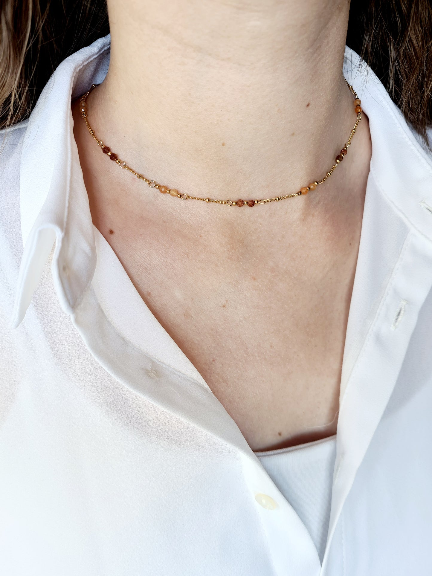 Évasion est un collier en acier inoxydable doré composé de véritable pierres naturelles