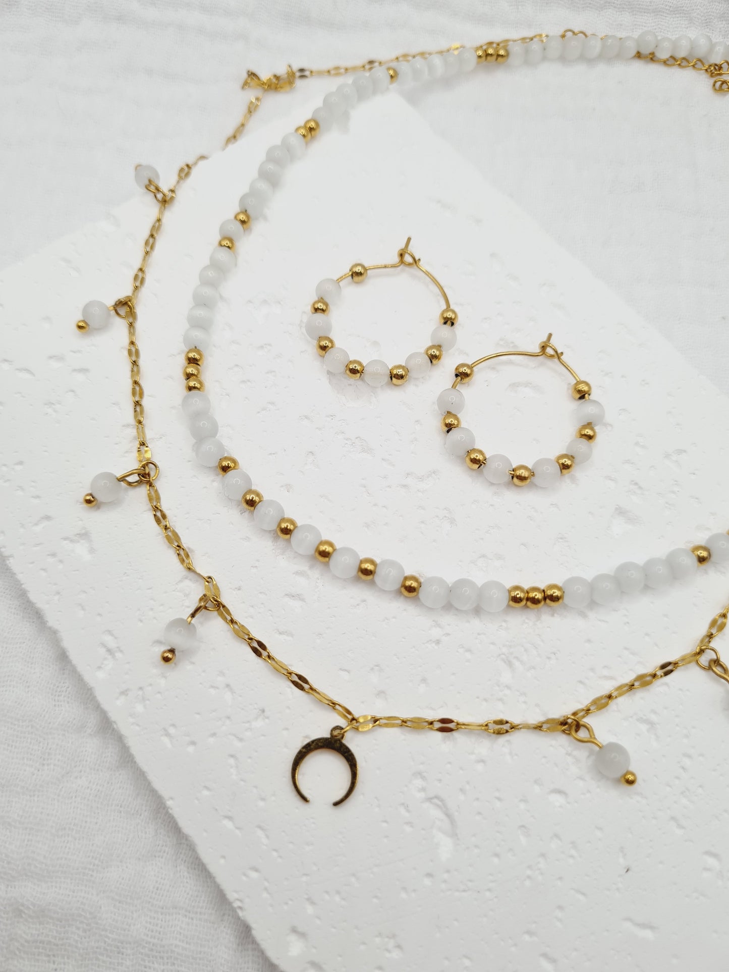 Lunaire est une parure de bijoux en acier inoxydable doré composée de véritables pierres naturelles