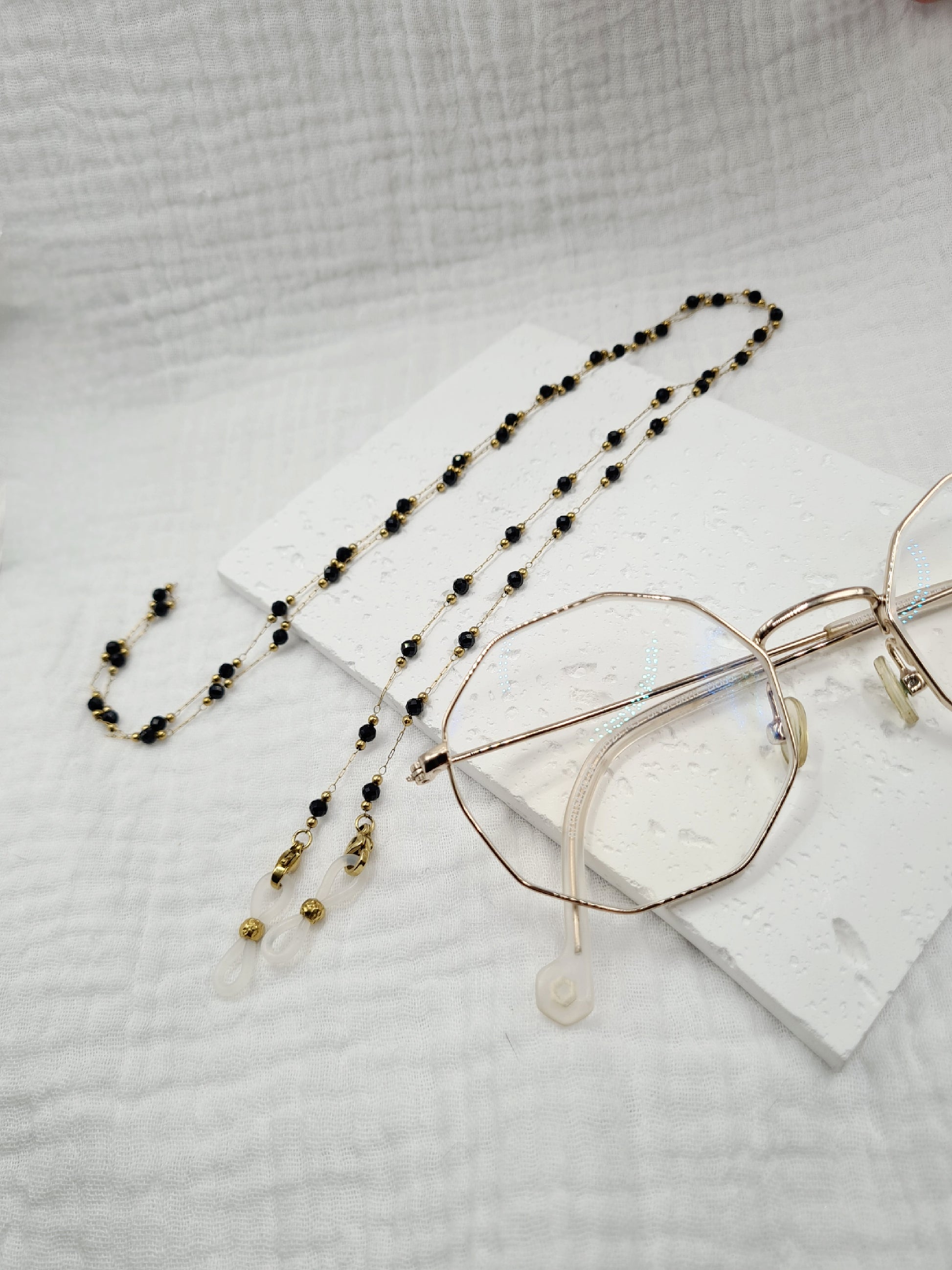 Sigrytita est une chaîne de lunettes en acier inoxydable doré composée de pierres naturelles
