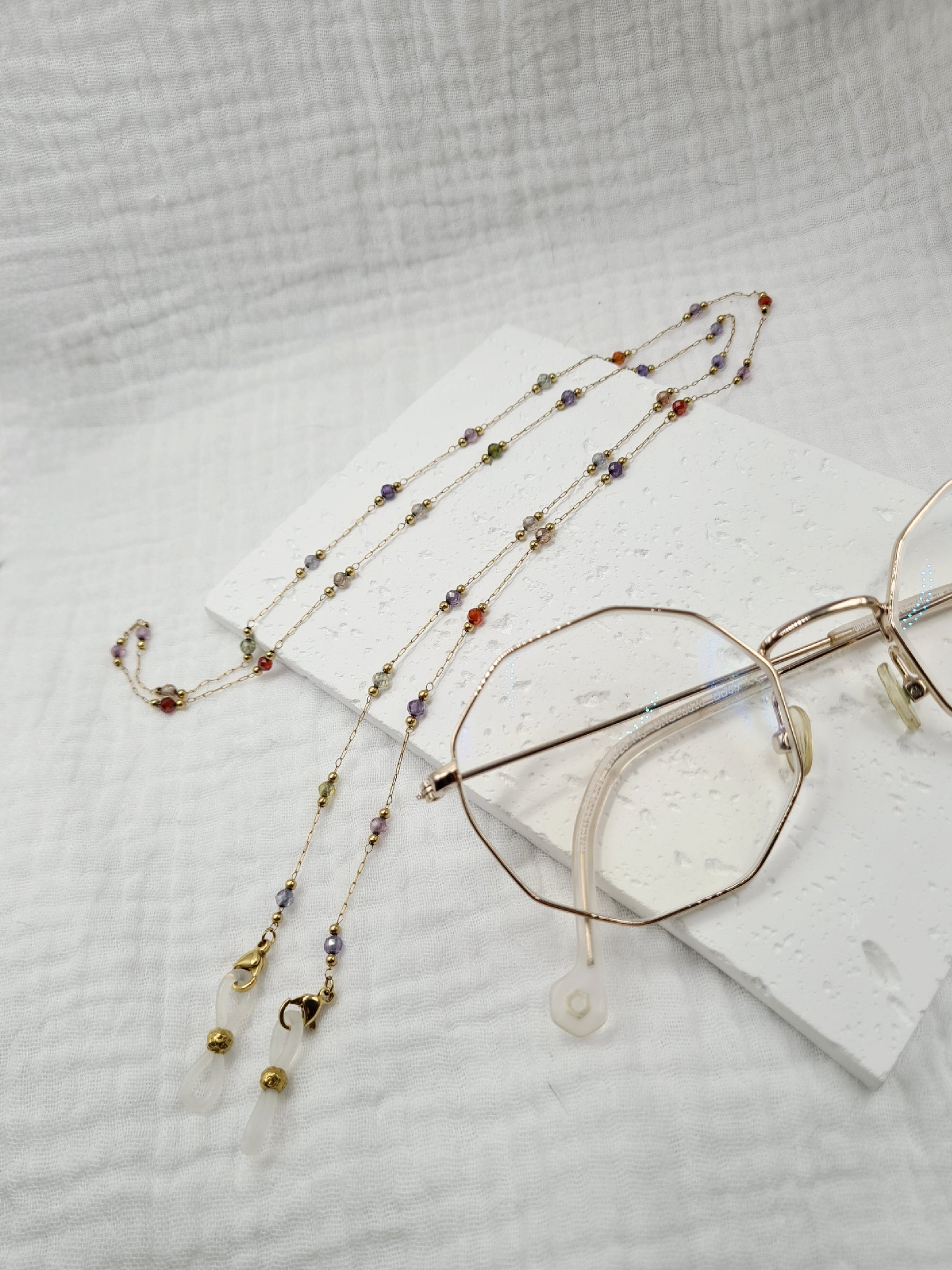 Sigrytita est une chaîne de lunettes en acier inoxydable doré composée de pierres naturelles