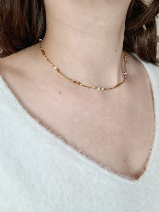 Évasion est un collier en acier inoxydable doré composé de véritable pierres naturelles
